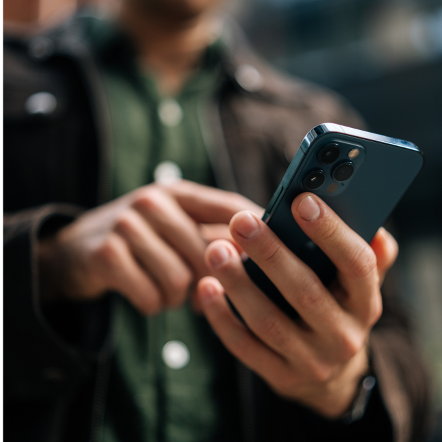 Image of man holding mobile phone blurred background
