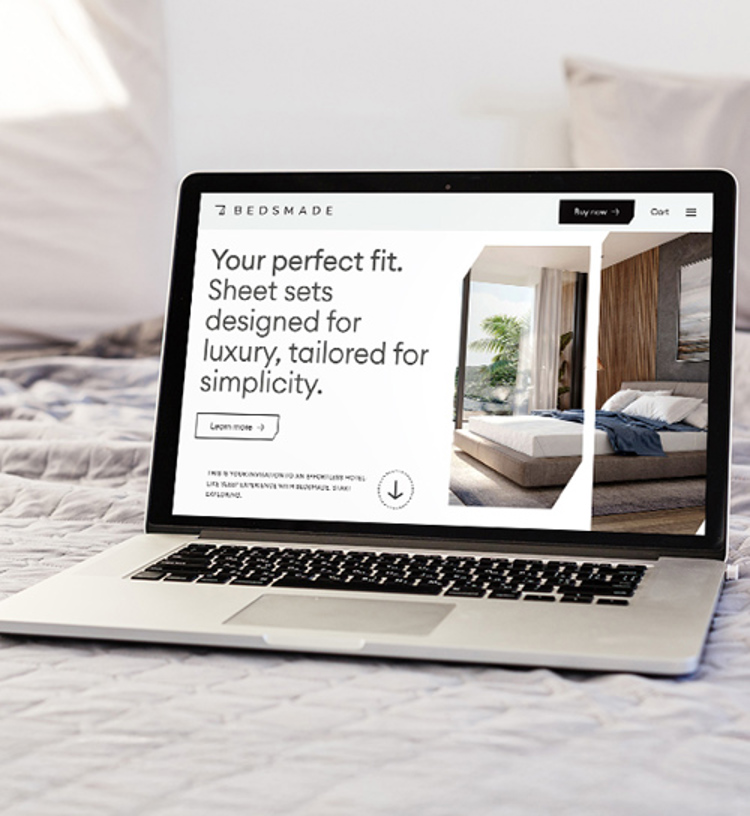Bedsmade homepage on a laptop that is placed on a bed