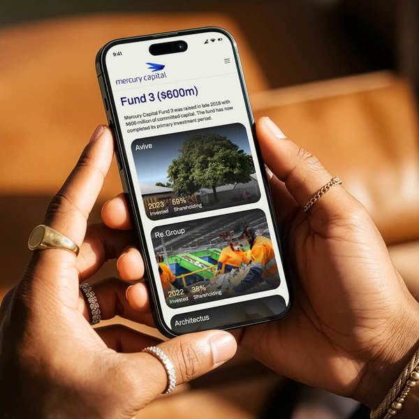 A person holding a mobile phone that is displaying the Portfolio page on the Mercury Capital website.