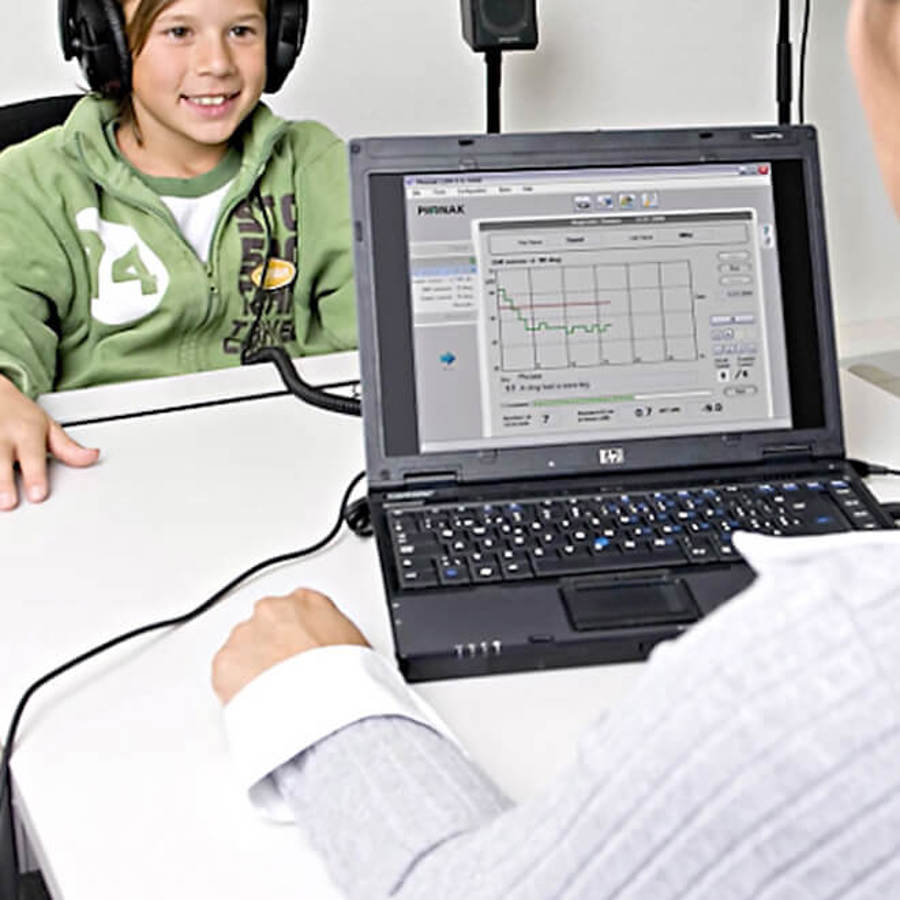 Child in clinic with audiologist for hearing assessment